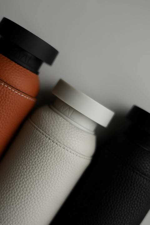 NAAL glass water bottles with leather sleeves